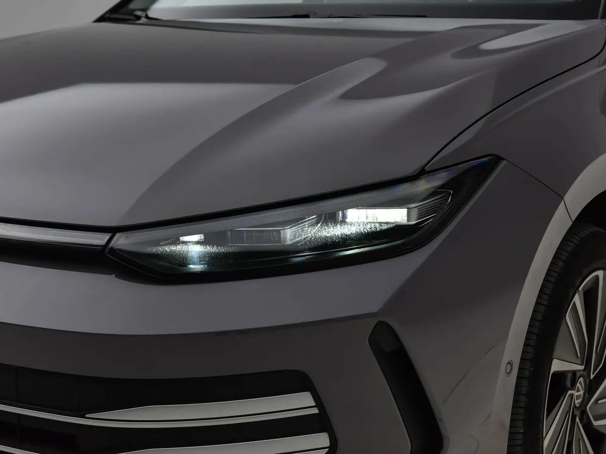 Светодиодная фара и капот серого Volkswagen Lavida Pro крупным планом, внизу хромированная планка решётки
