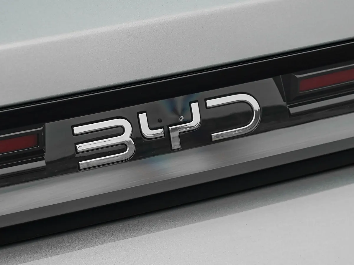 Хромированная надпись BYD на чёрной панели в задней части кузова