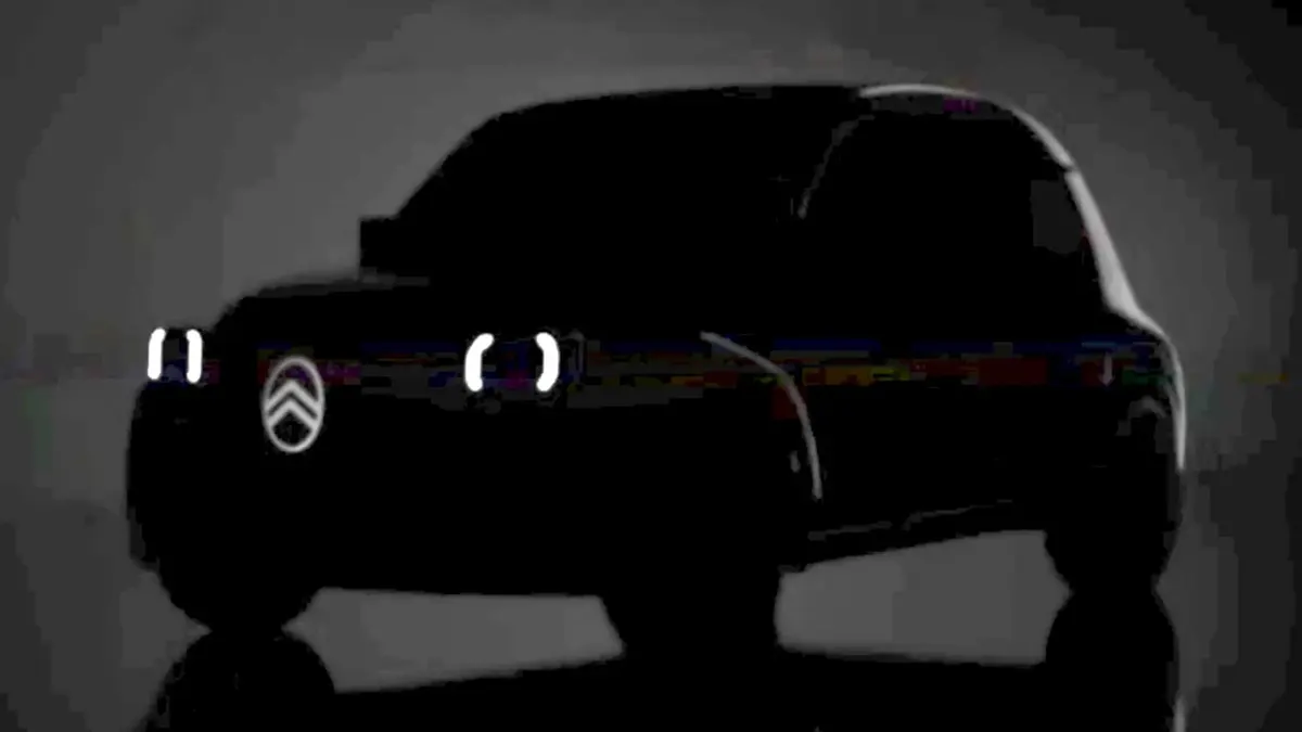 Тёмный силуэт автомобиля с подсвеченным логотипом Citroën и двумя светящимися фарами-скобками