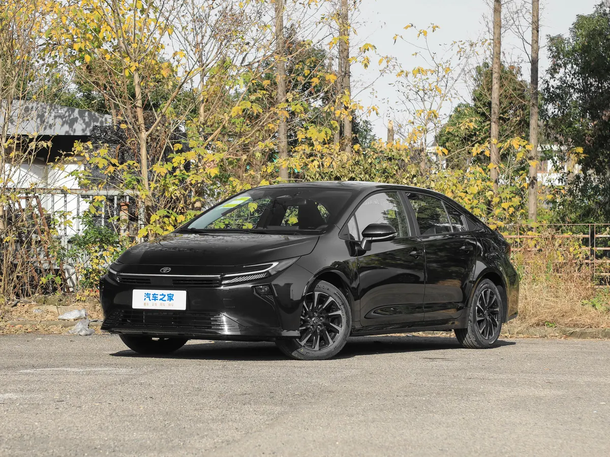 Чёрный седан Toyota на фоне деревьев с жёлтой осенней листвой