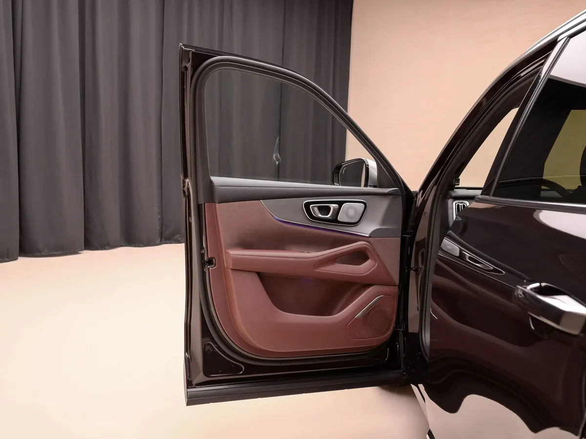 Открытая передняя дверь Geely Xingyue L PLUS: бордовая обивка, хромированная ручка, динамик и контурная подсветка