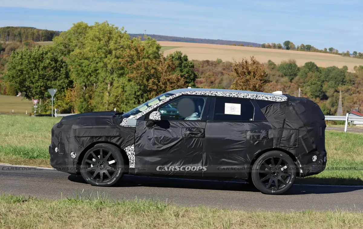 Профиль замаскированного Kia Sportage: прямая линия кузова, чёрные диски и накладки в камуфляжной расцветке