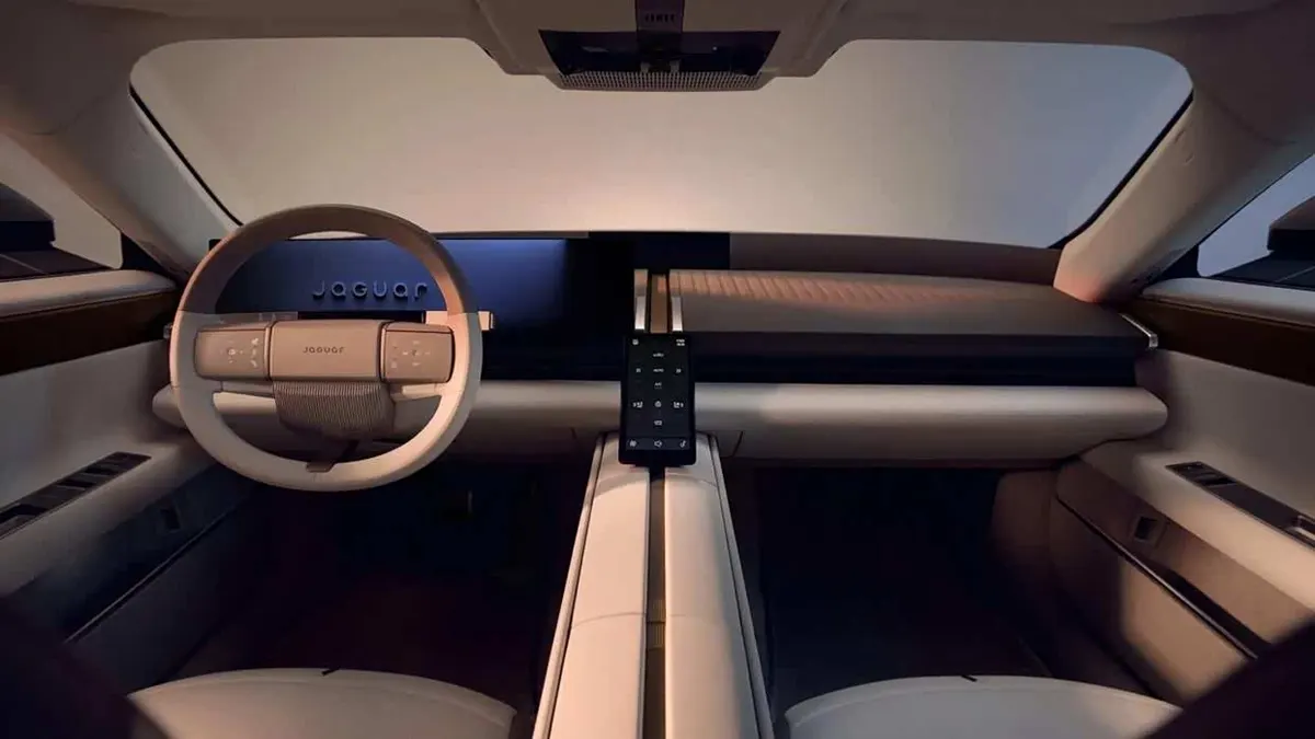 Салон Jaguar Type 01: светлый руль с надписью Jaguar, вертикальный экран на консоли