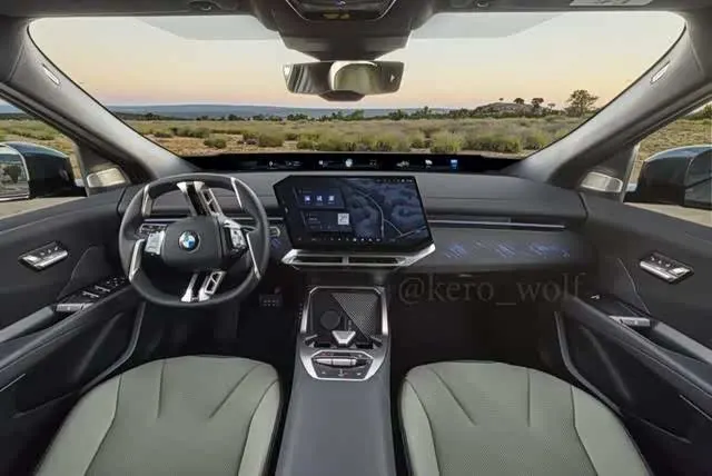 Салон BMW iX4: руль с логотипом BMW, широкий дисплей с навигацией и серо-зелёные сиденья