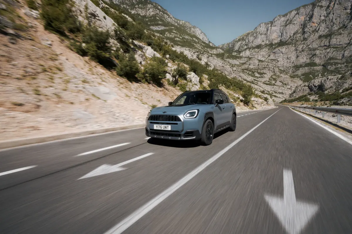 MINI Countryman Untamed Edition едет по горной дороге, по сторонам скалы и кустарник