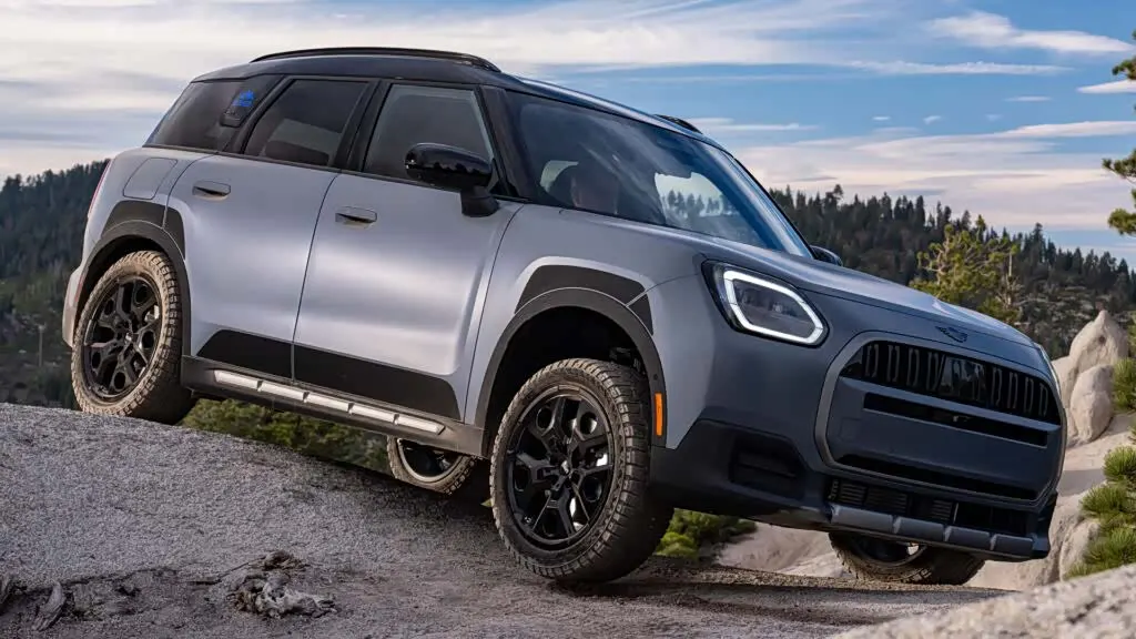 MINI Countryman Untamed Edition на каменистом склоне среди сосен, видны шины для бездорожья и накладки на порогах