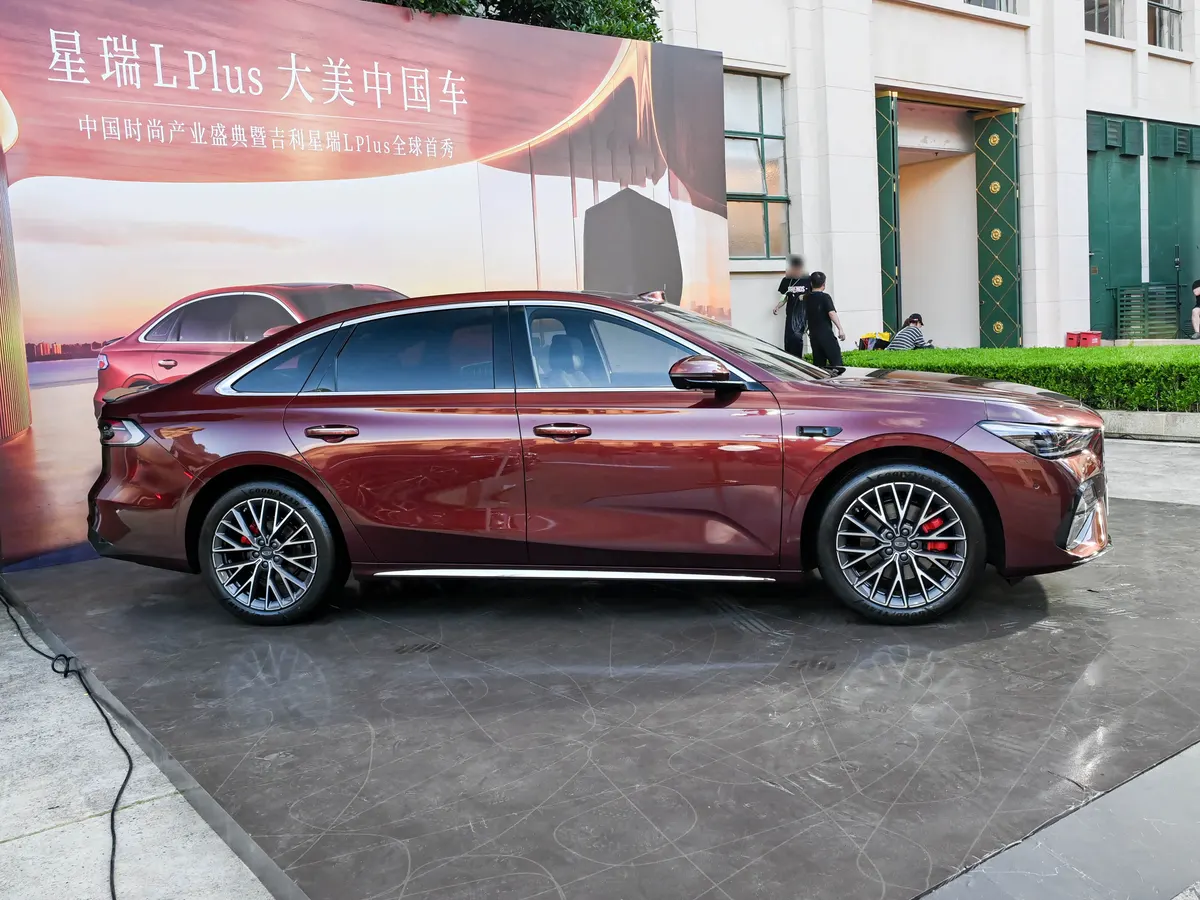 Geely Xingrui L PLUS, вид сбоку: бордовый седан со спицевыми дисками и красными суппортами на выставке