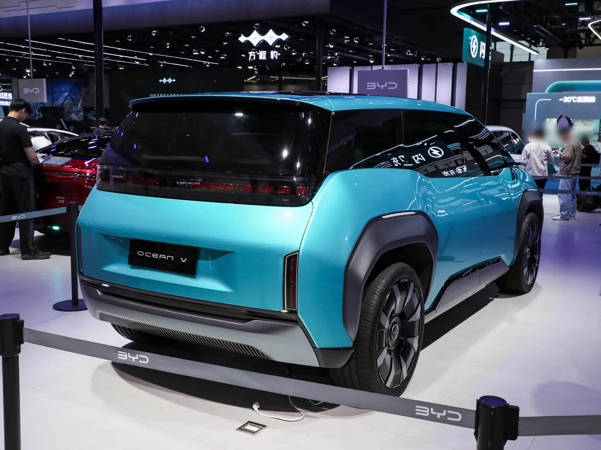 Бирюзовый концепт BYD Ocean V сзади-сбоку на выставке, на номерной табличке надпись Ocean V