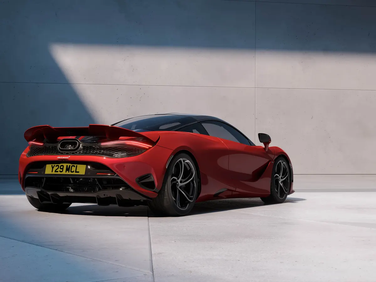Красный McLaren 750S сзади в три четверти: большое заднее антикрылья и жёлтый номерной знак