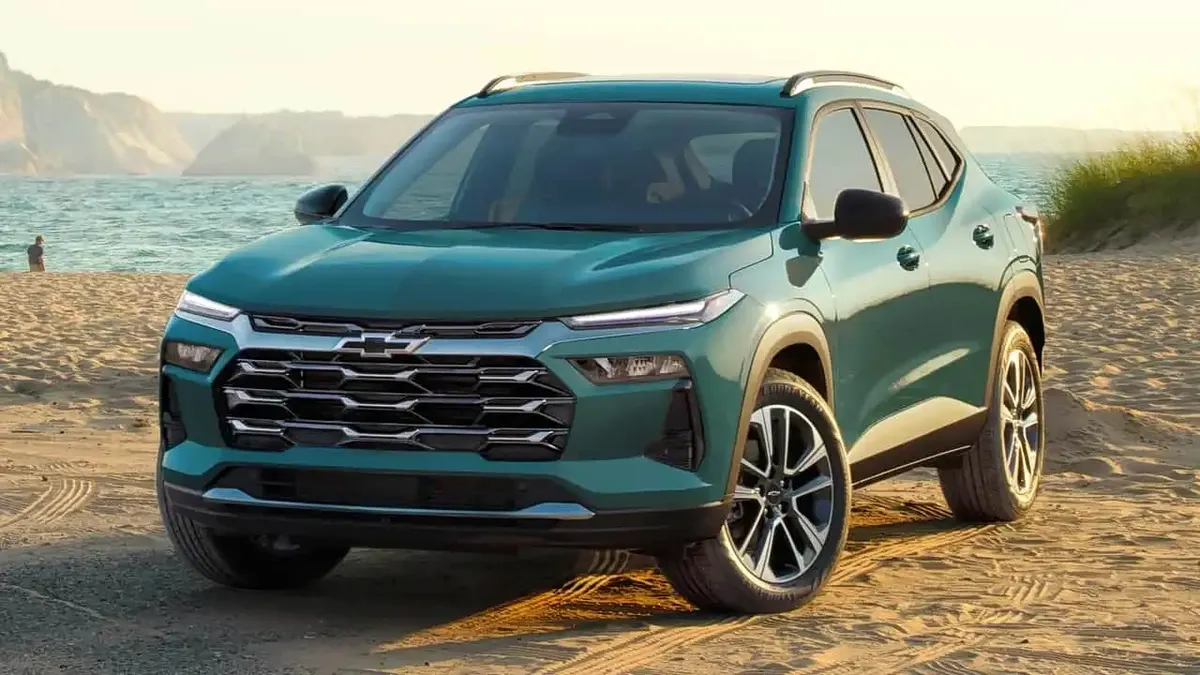 Зелёный Chevrolet Trax на песчаном пляже на фоне моря, вид спереди