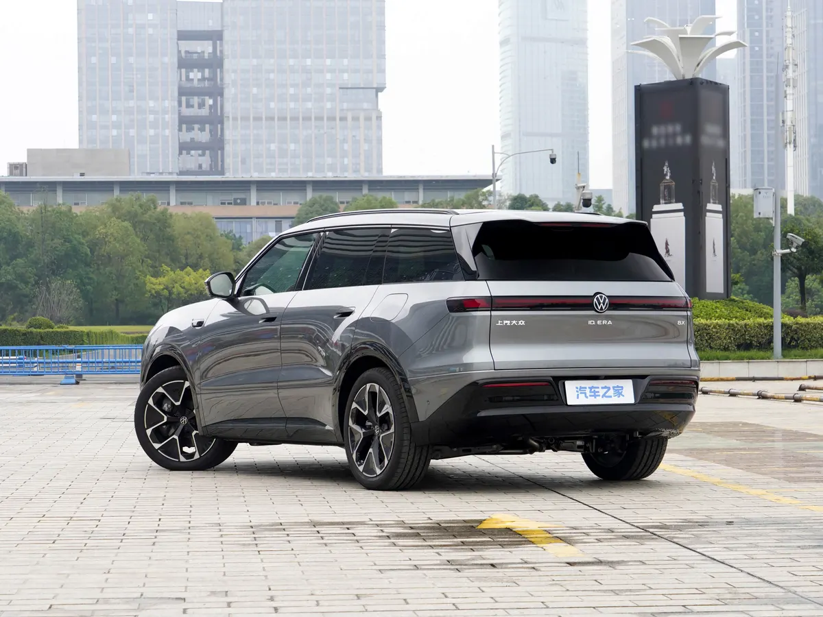 Серый ID.ERA 8X сзади: полоса задних фонарей, эмблема VW, на фоне городские здания