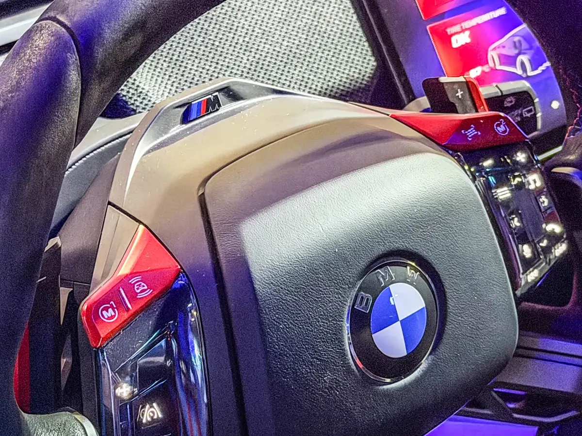 Рулевое колесо BMW M Concept вблизи: логотип BMW, красные кнопки M и подрулевой переключатель