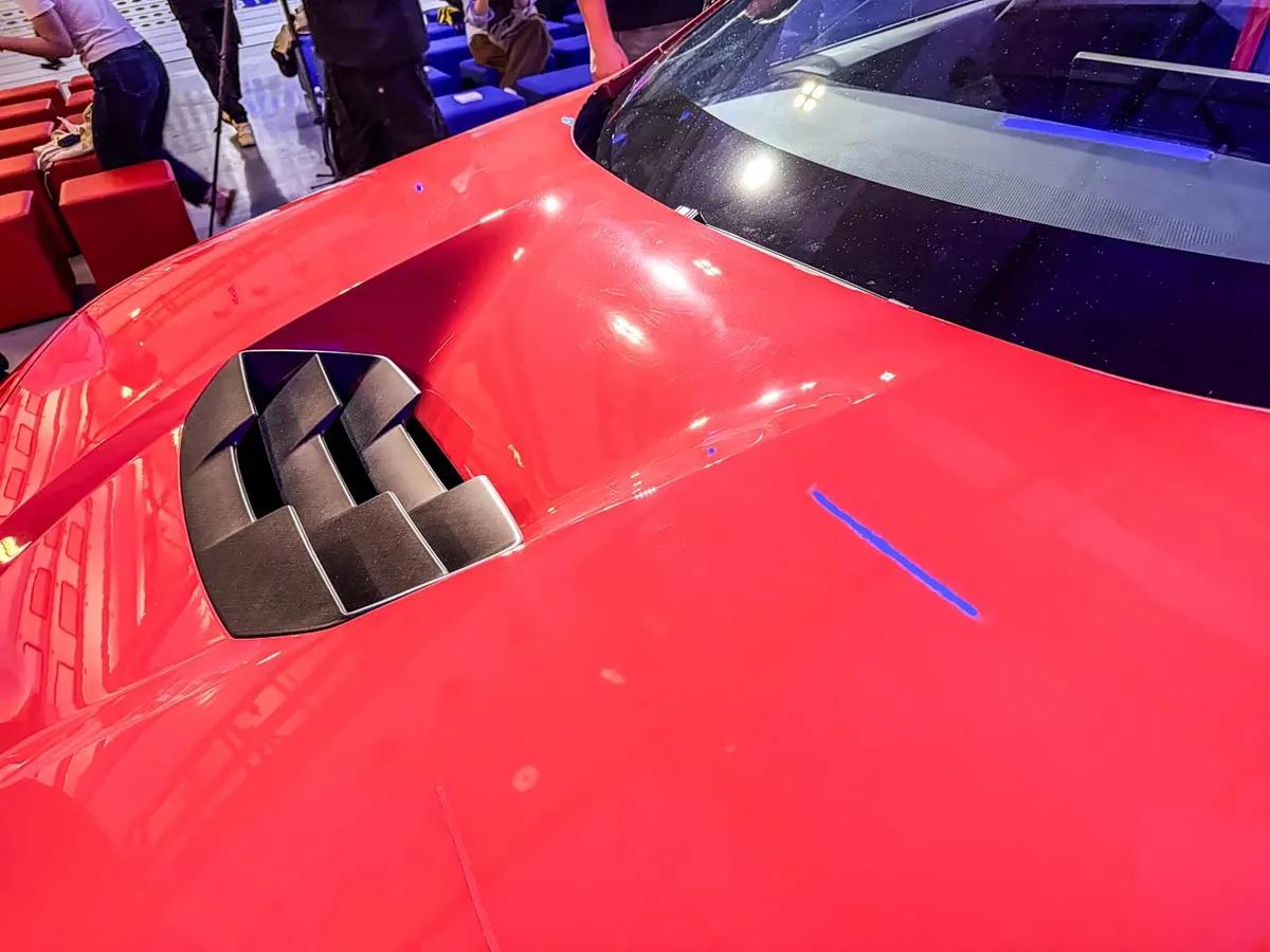 Капот красного BMW M Concept Neue Klasse с воздухозаборником с чёрными рёбрами
