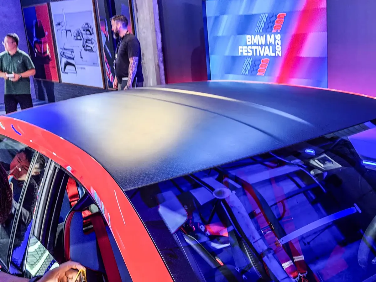 Матовая чёрная крыша красного BMW M Concept, сквозь лобовое стекло видны красные ремни безопасности