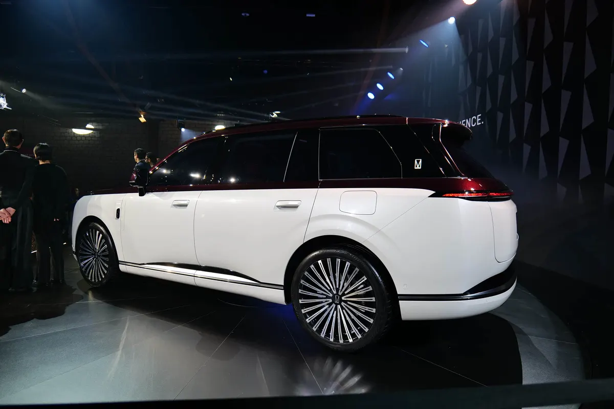 Бело-бордовый Avatr Concept T09, вид сзади сбоку: массивные спицевые диски, тонкий горизонтальный задний фонарь