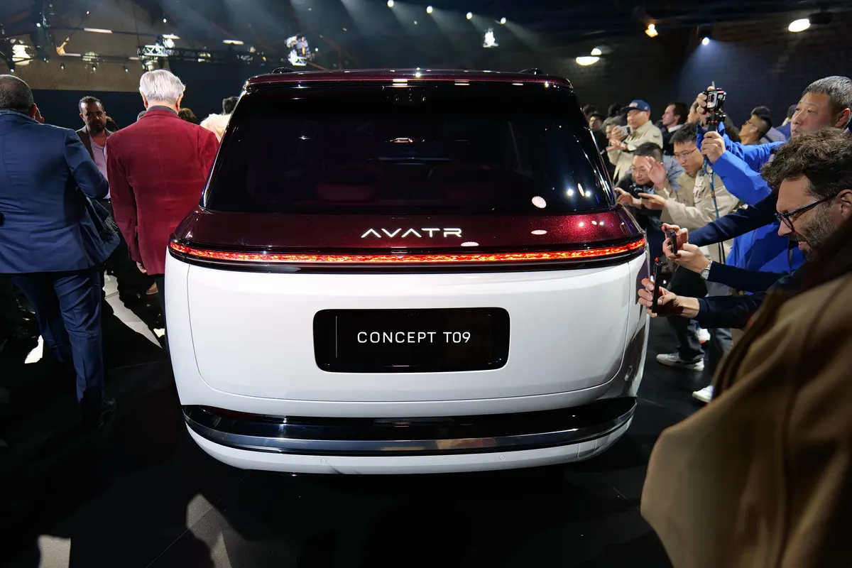 Вид сзади на Avatr Concept T09: сплошная светодиодная полоса фонарей, вокруг машины фотографирующие гости