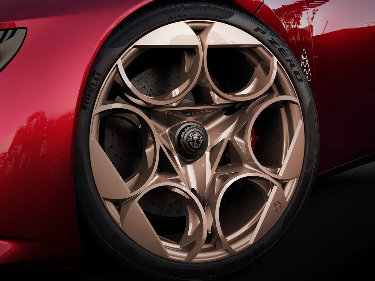 Бронзовый диск с круглыми прорезями и шиной Pirelli P Zero на Alfa Romeo Cuorerosso крупным планом