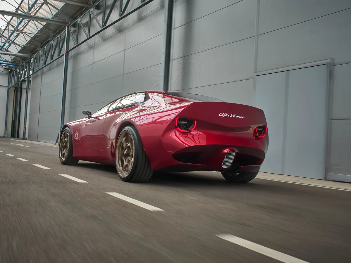 Alfa Romeo Cuorerosso в движении в ангаре, вид сзади: бронзовые диски и круглые красные фонари