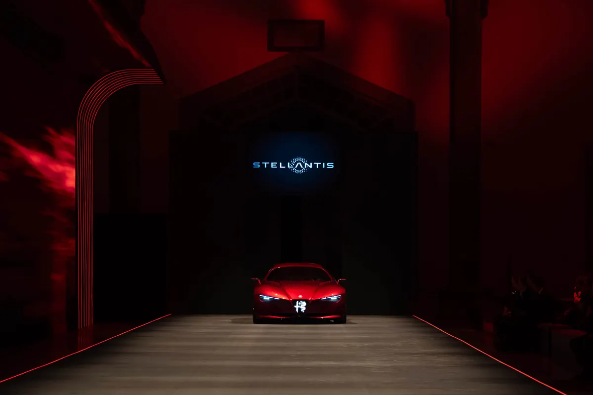 Alfa Romeo Cuorerosso спереди в конце подиума, над ним на экране логотип Stellantis