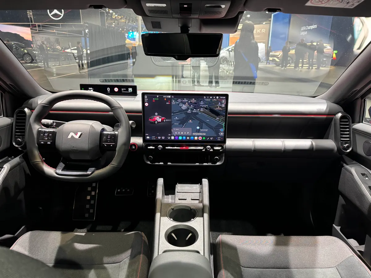 Салон IONIQ 3 N Line: руль с логотипом N, экран с навигацией, тёмные сиденья с красной строчкой