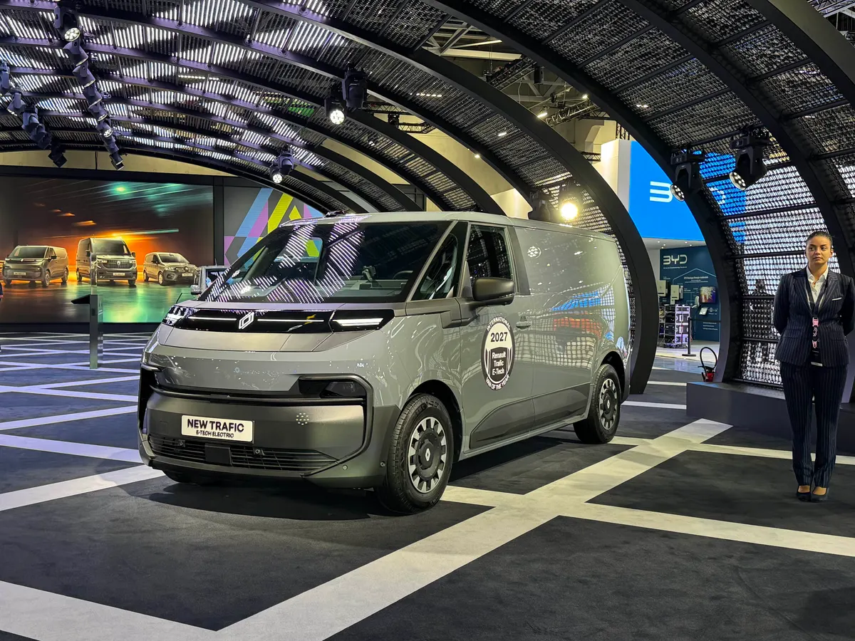 Серый электрический Trafic E-Tech на стенде, на двери наклейка «Фургон года 2027»