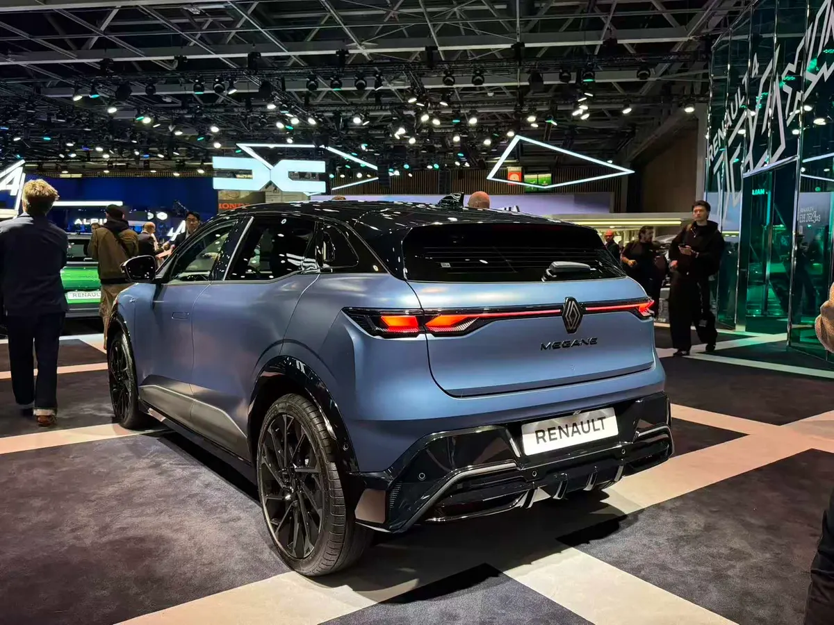 Mégane E-Tech сзади: тонкая полоса фонарей и чёрный диффузор, выставочный стенд
