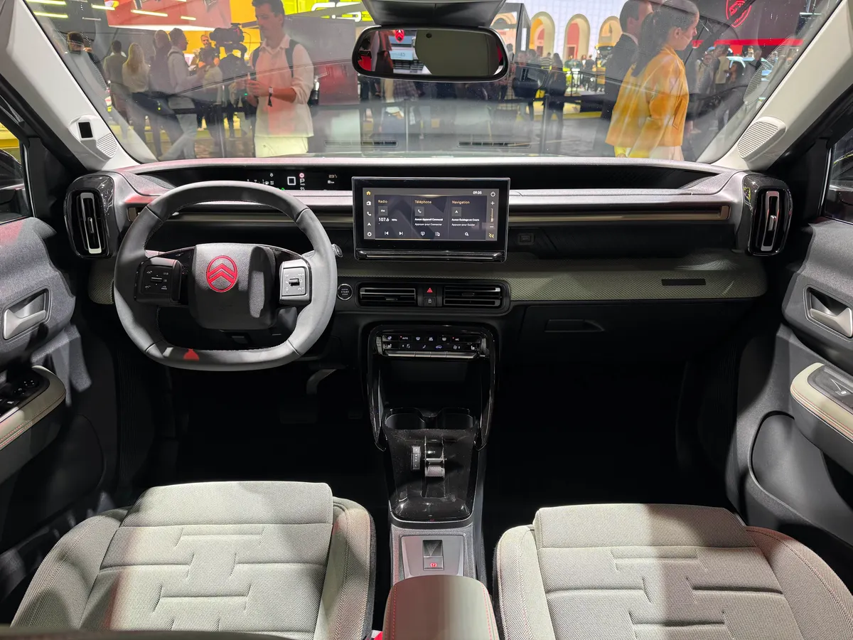 Салон Citroën C3 Aircross: руль с красным логотипом, небольшой сенсорный экран и тканевые сиденья