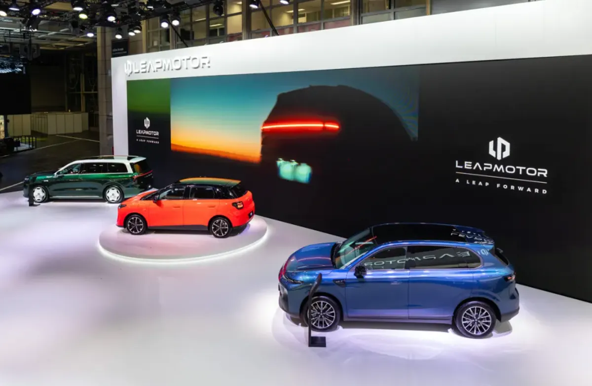 Стенд Leapmotor на автосалоне: зелёный, оранжевый и синий автомобили на фоне большого экрана