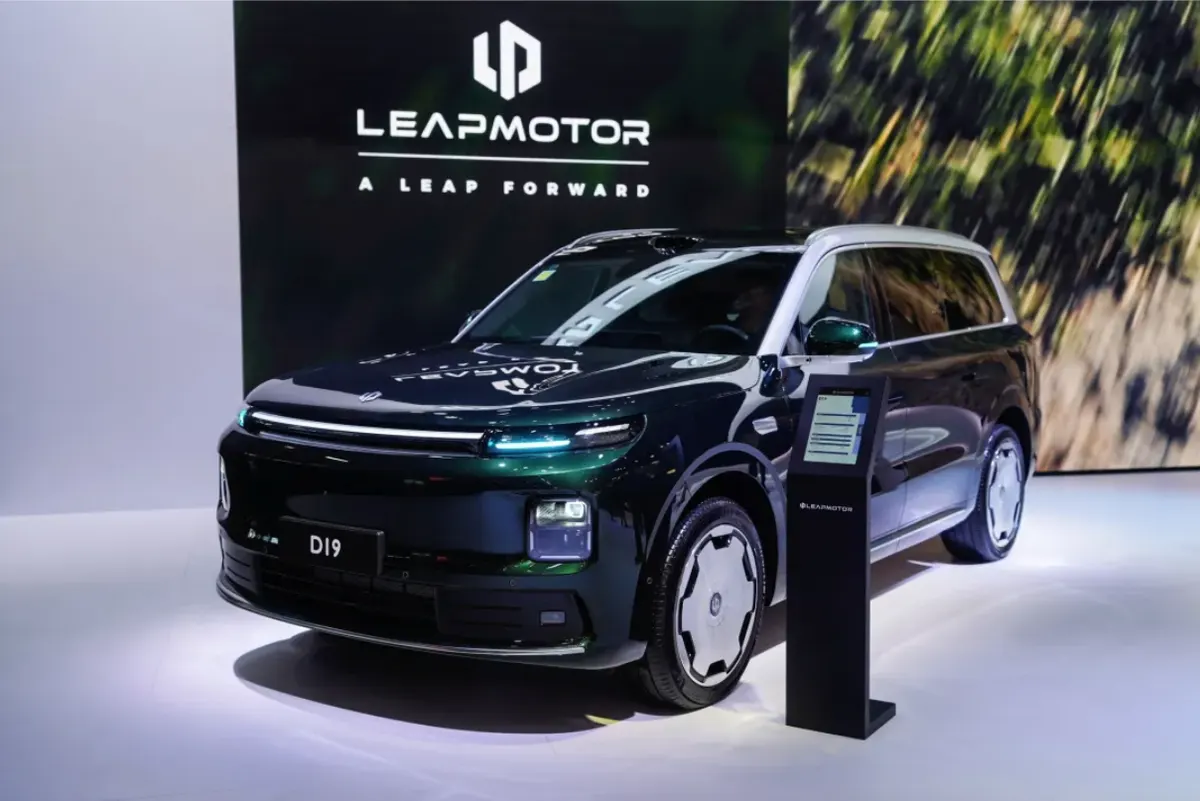 Тёмно-зелёный Leapmotor D19 с серебристой крышей на стенде рядом с информационной стойкой