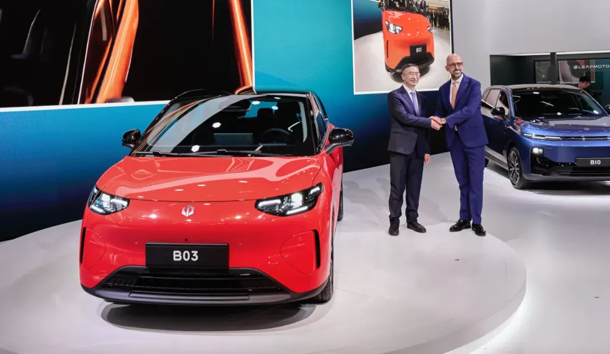 Двое мужчин в костюмах пожимают руки у красного хэтчбека Leapmotor, позади стоит синий B10