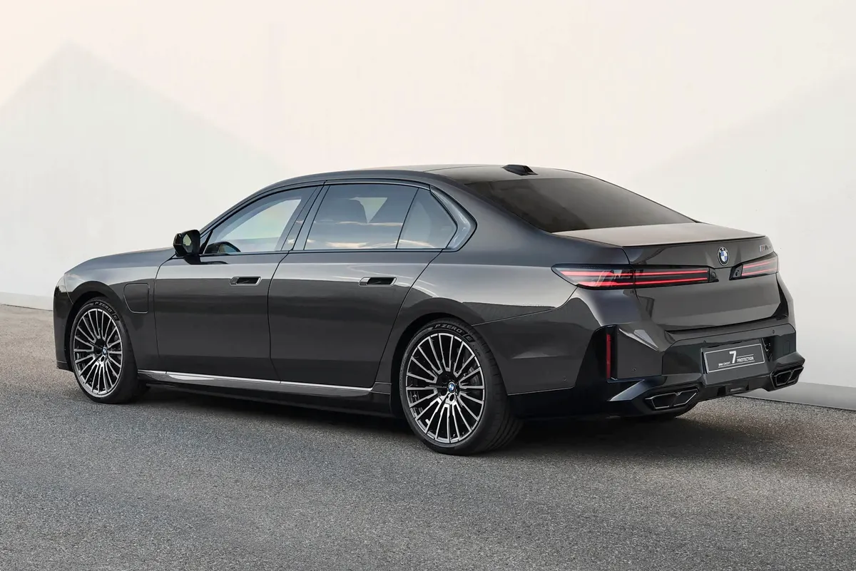 BMW Concept 7 Protection сзади в три четверти: тёмно-серый седан, узкие красные фонари, многоспицевые диски