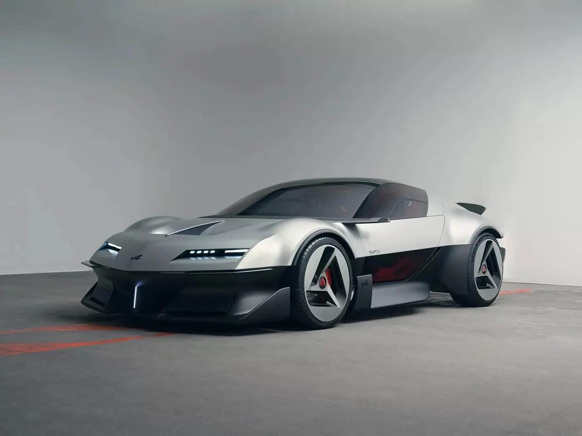 Концепт Alpine A310 VISION в серебристо-чёрном цвете, вид спереди сбоку, в студии с красной разметкой на полу