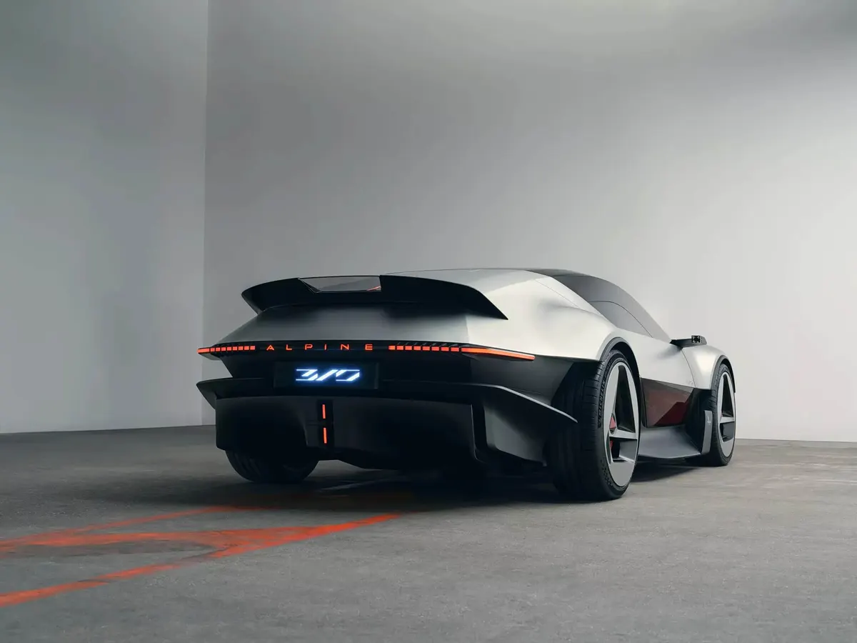 Концепт Alpine A310 VISION сзади сбоку: широкое антикрыло, светящаяся надпись Alpine и огни по ширине кузова