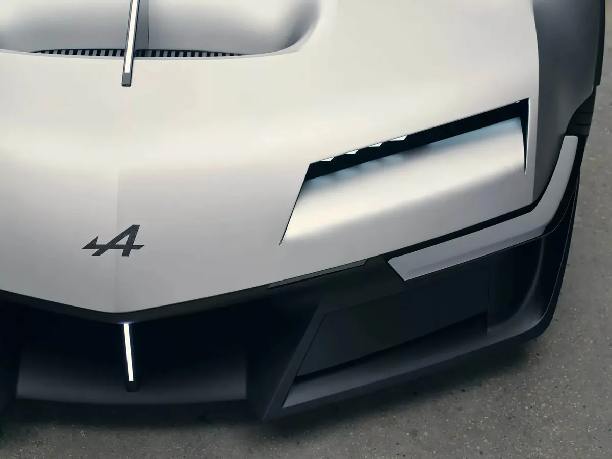 Передняя часть концепта Alpine A310 VISION вблизи: логотип, узкая фара и тёмный бампер с воздухозаборниками