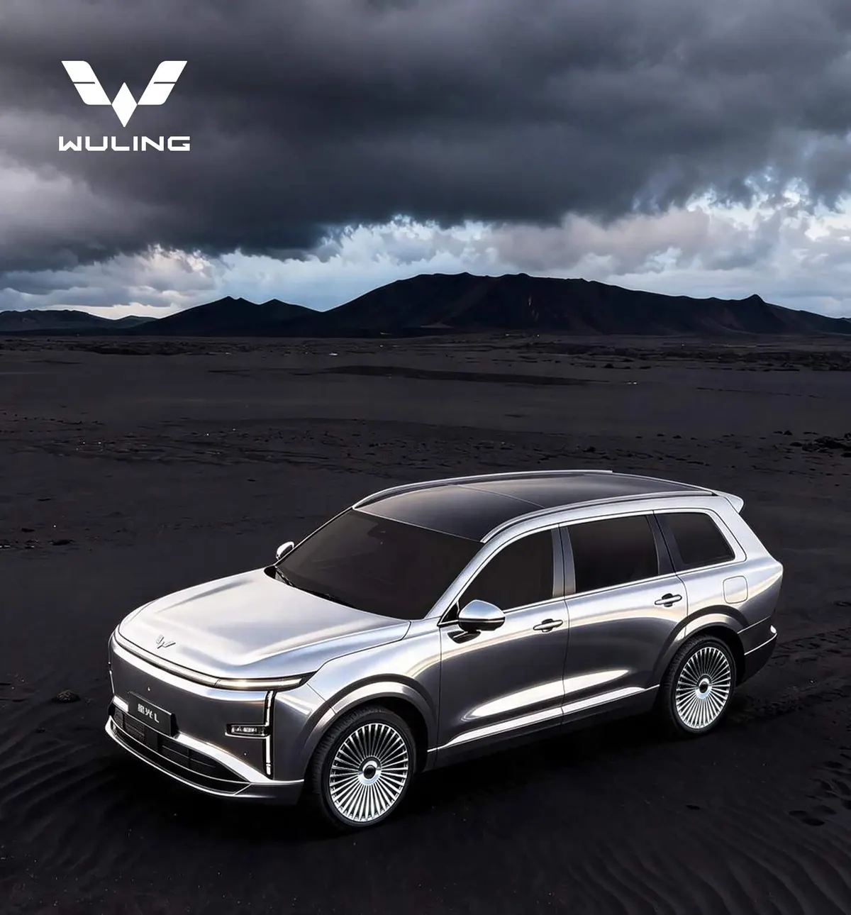Серебристый кроссовер Wuling Starlight L, вид спереди и сверху, на чёрном песке под грозовыми тучами