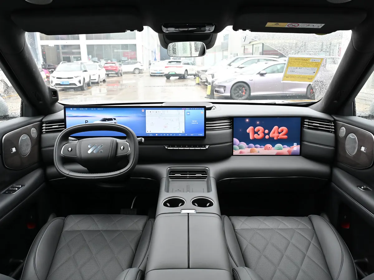 Салон IM LS8 NEO: два широких экрана на панели, овальный руль и серые кожаные сиденья с ромбовидной стёжкой