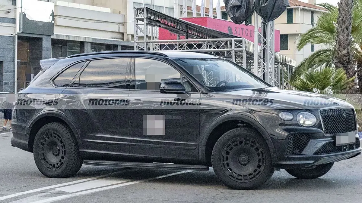 Bentley Bentayga X сбоку и спереди на городской улице: чёрные диски, шины с крупным протектором, боковая подножка