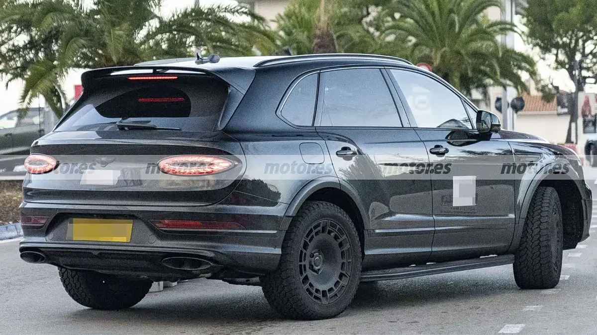 Bentley Bentayga X сзади в три четверти: овальные фонари, спойлер, два выхлопных патрубка, жёлтый номер
