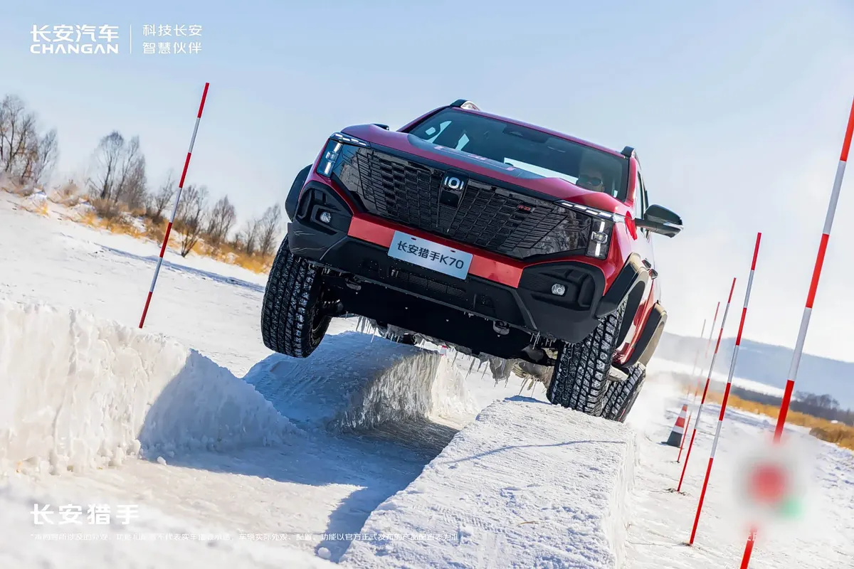 Красный пикап Changan Hunter K70 преодолевает снежные препятствия между красно-белыми вехами
