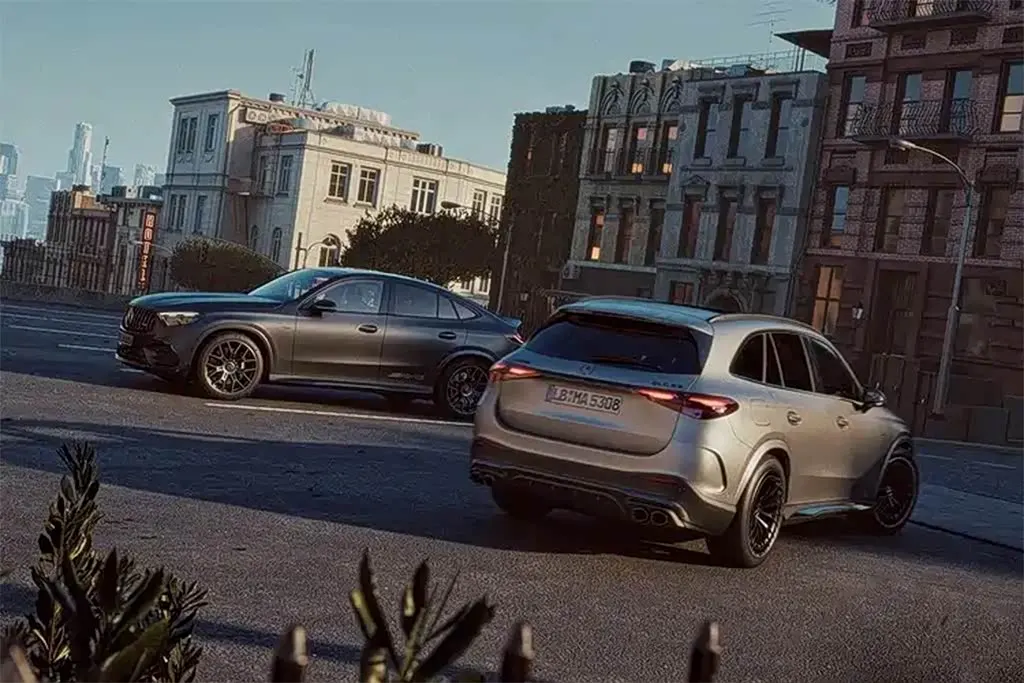 Два кроссовера Mercedes-AMG на городской улице: серебристый сзади и тёмно-серый купе-кроссовер