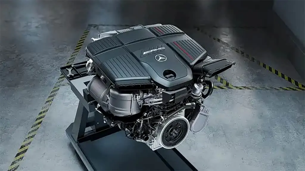 Двигатель Mercedes-AMG с эмблемами на декоративной крышке, установленный на стенде в ангаре