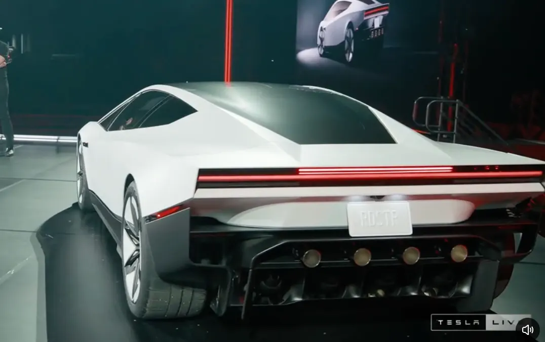 Roadster сзади-сбоку на сцене: красная полоса фонаря, номер RDSTR, четыре выхлопных сопла