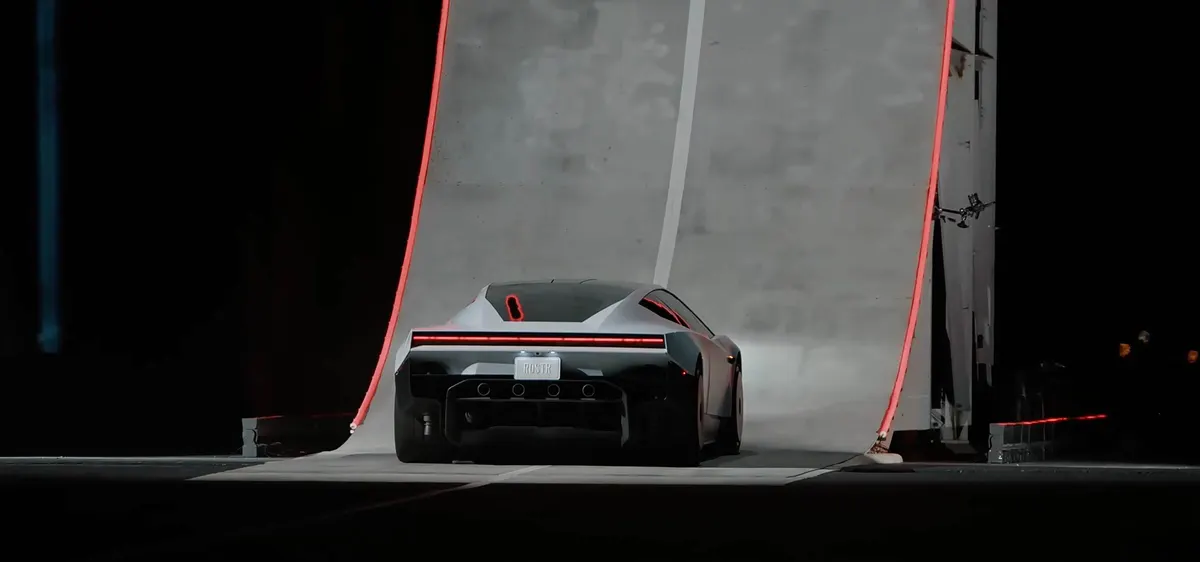Roadster сзади на изогнутой бетонной рампе с красной подсветкой по краям, номерной знак RDSTR