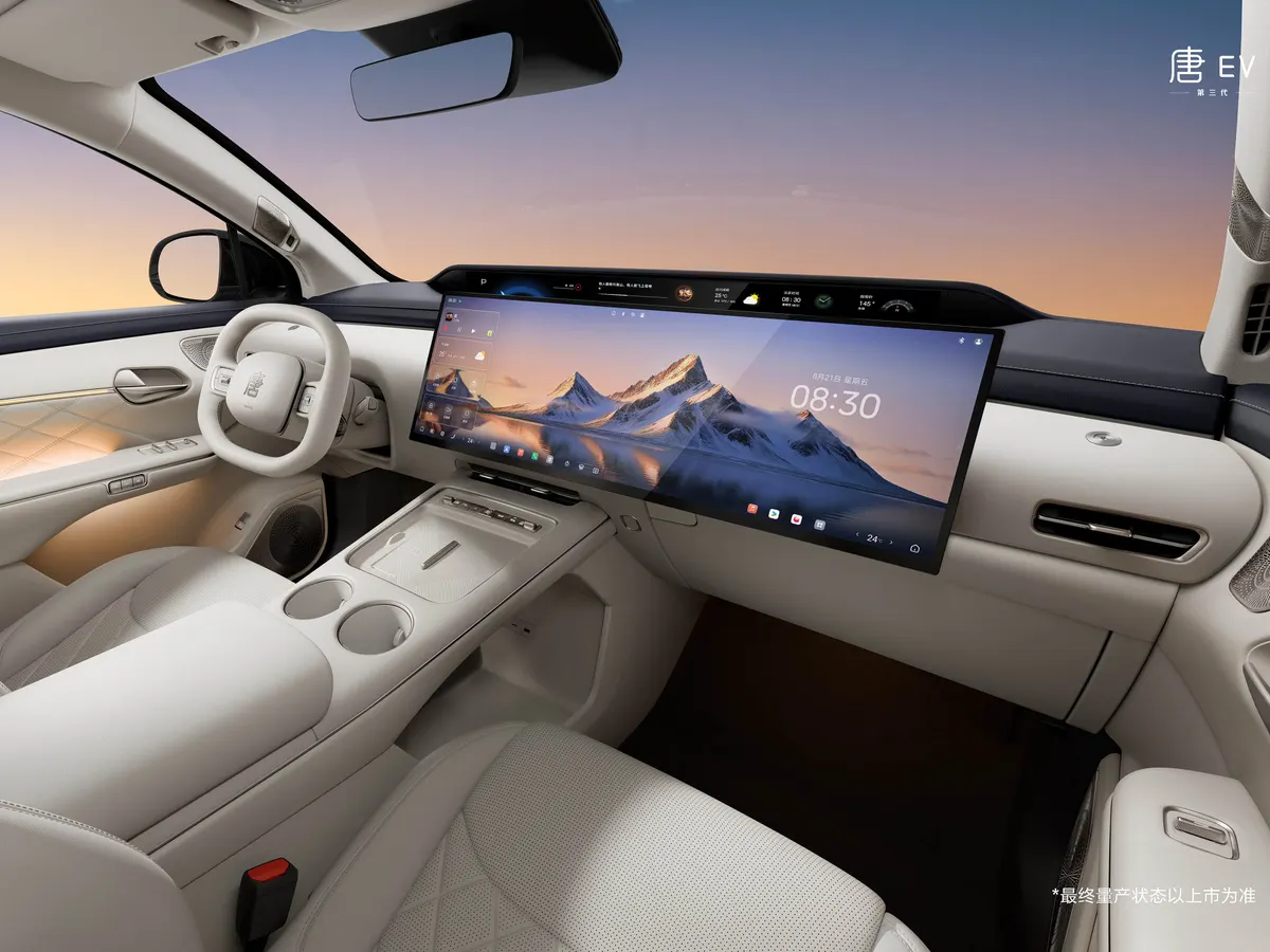 Светлый салон BYD Tang: широкий экран с горным пейзажем, белый руль, центральная консоль