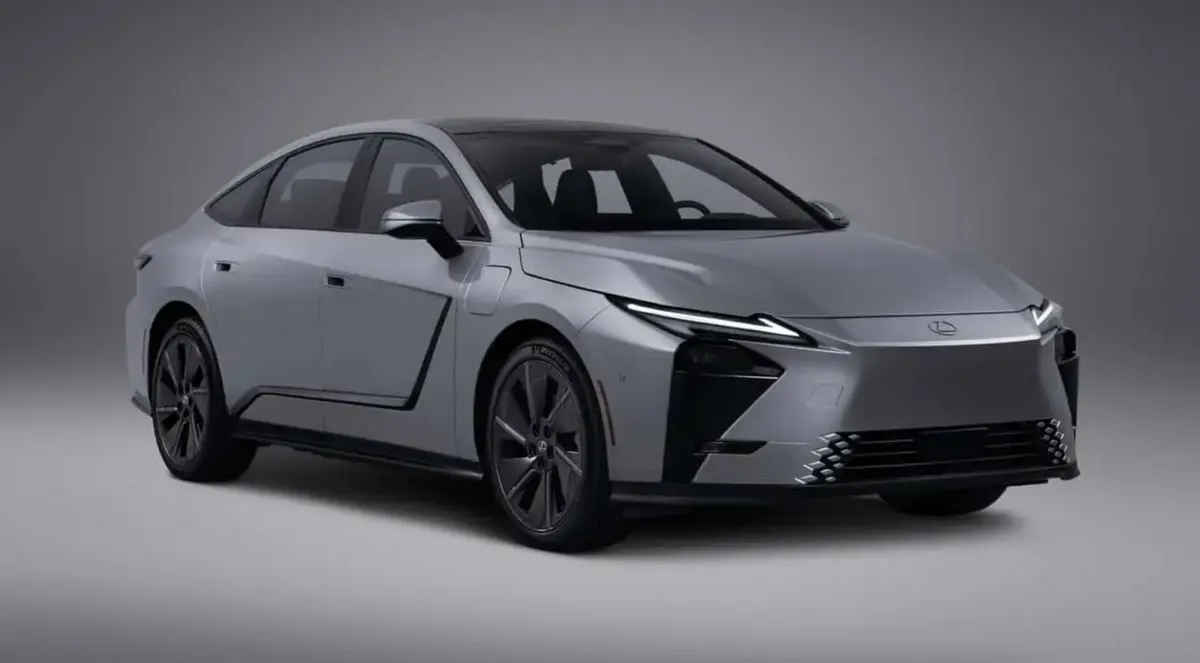 Серый седан Lexus ES 350e в студии: вид спереди-сбоку, узкие фары, чёрные вставки в бампере и тёмные диски