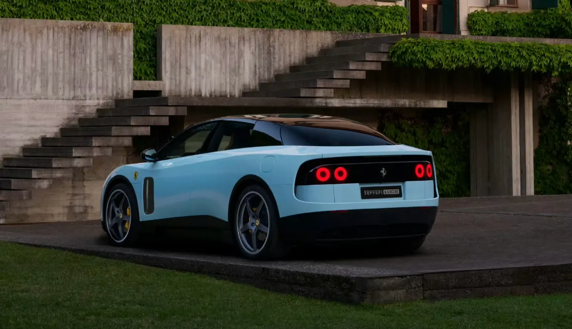 Голубой Ferrari LUCE сзади: круглые красные фонари, на заднем плане бетонная лестница с плющом