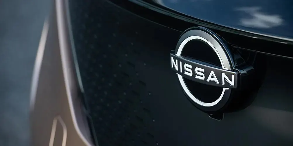 Логотип Nissan на чёрной передней панели автомобиля крупным планом