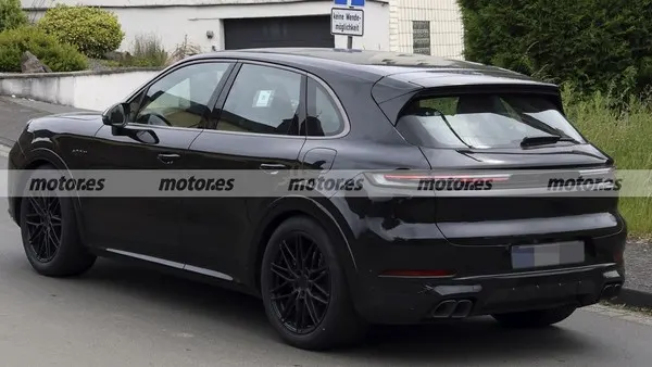 Тот же чёрный Porsche Cayenne Turbo E-Hybrid сзади сбоку: спойлер на крыше, узкие задние фонари, выхлопные патрубки