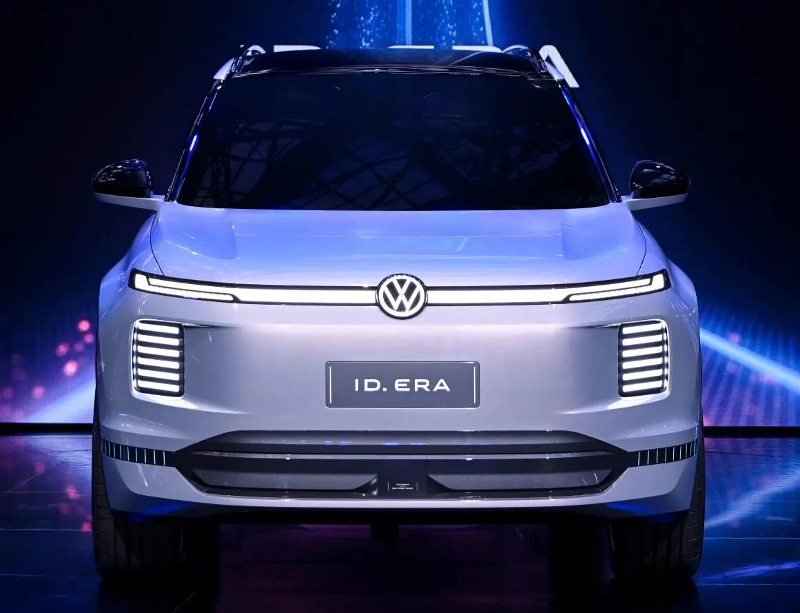 Серебристый внедорожник Volkswagen, вид спереди: световая полоса с логотипом, сцена с синей подсветкой