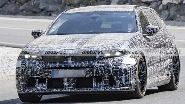 Прототип BMW M5 Touring в камуфляжной плёнке, вид спереди: узкие фары, решётка радиатора и чёрные диски